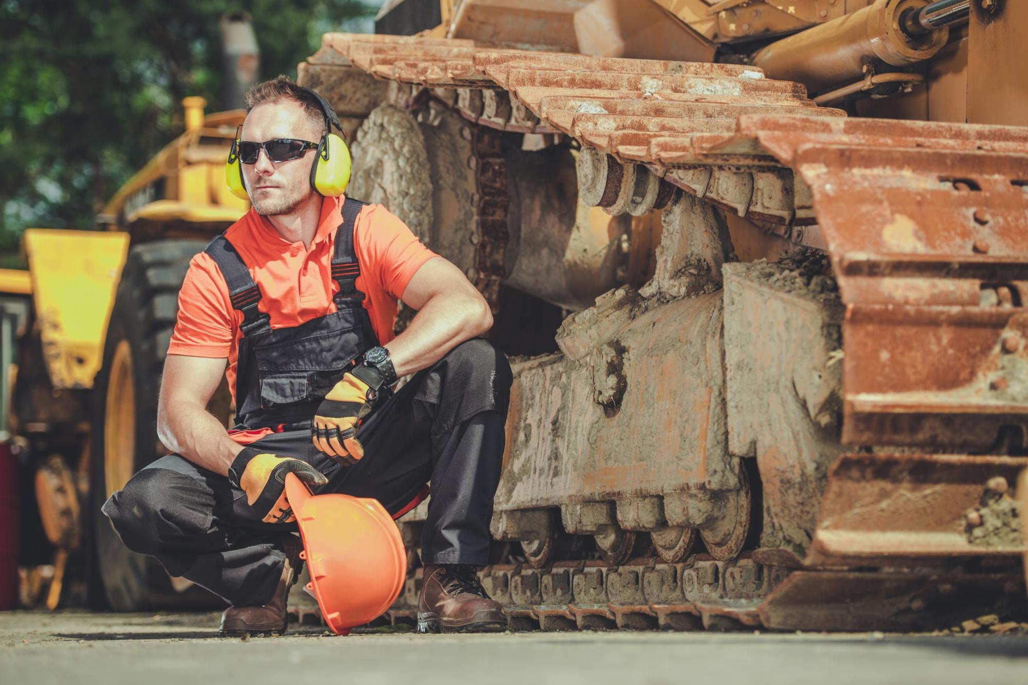 mechanik przy gąsienicach od koparki